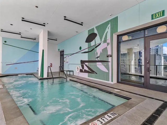 a kitchen with stainless steel appliances kitchen island granite countertop a table chairs and a refrigerator