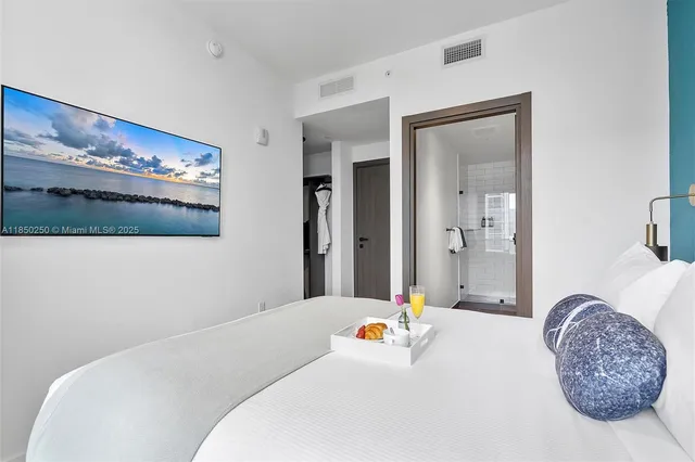 a bedroom with a bed and a painting on the wall