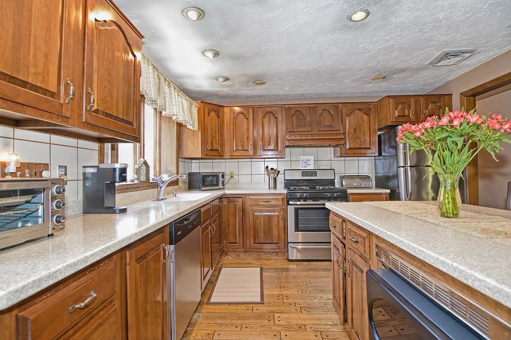 50 Cedarcrest Road Canton, MA 02021 - Photo 11 of 42 a kitchen with kitchen island granite countertop a sink counter top space appliances and cabinets