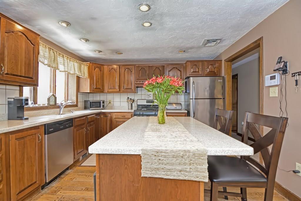 50 Cedarcrest Road Canton, MA 02021 - Photo 12 of 42 a kitchen with stainless steel appliances granite countertop sink stove and refrigerator