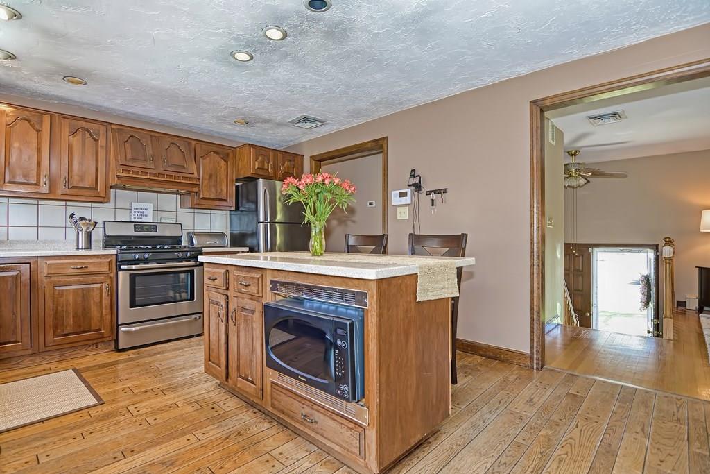 50 Cedarcrest Road Canton, MA 02021 - Photo 13 of 42 a kitchen with stainless steel appliances granite countertop a stove a sink and a refrigerator