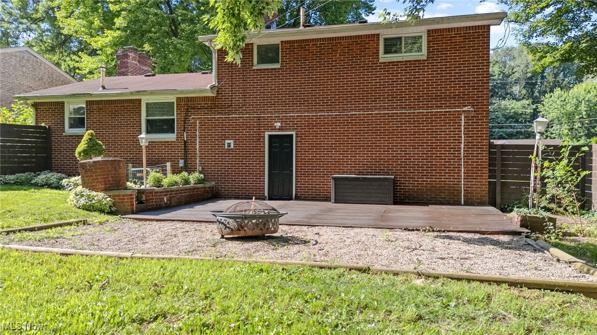 4895 3rd Street Northwest Canton, OH 44708 - Photo 23 of 27 Back of property featuring a fire pit, a deck, brick siding, a chimney, and a patio area