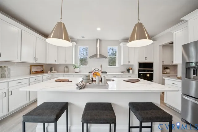 a kitchen with a sink a stove a refrigerator and white cabinets
