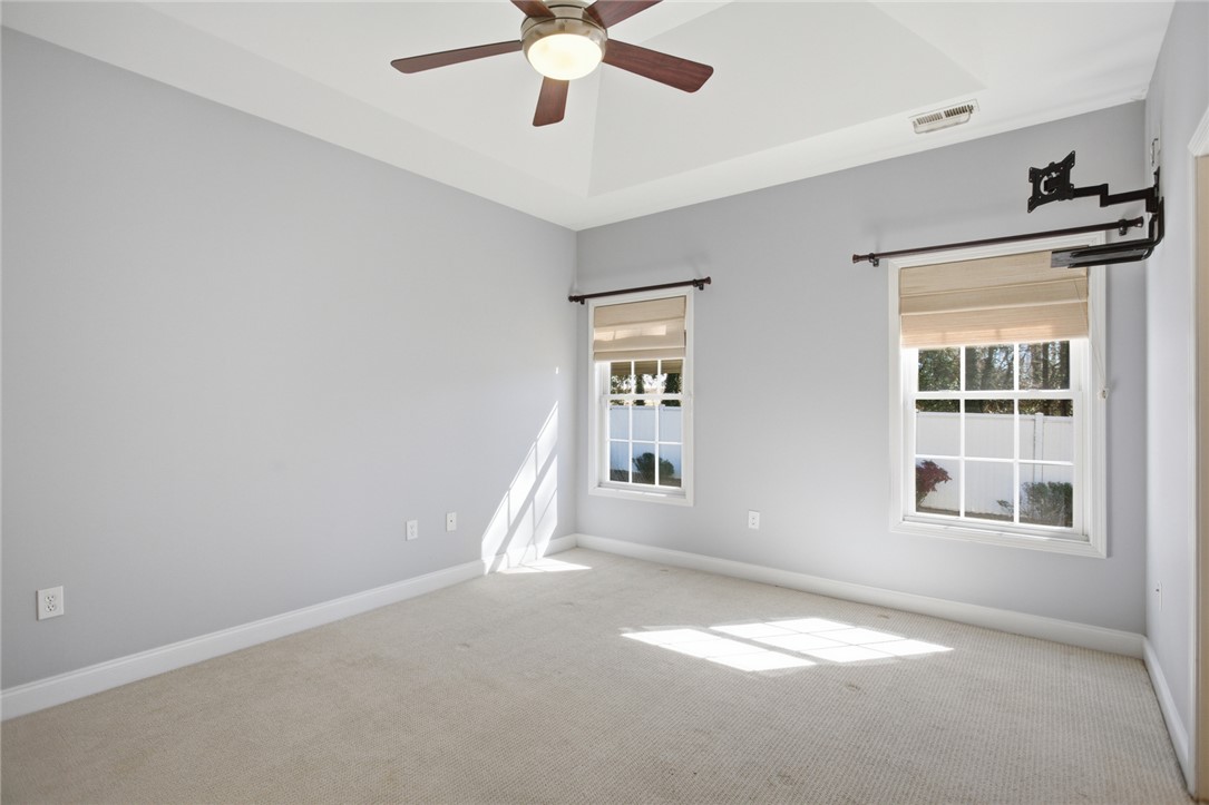 201 Providence Court Seneca, SC 29678 - Photo 16 of 33 This airy bedroom features large windows and a tray ceiling, creating a bright and inviting atmosphere.