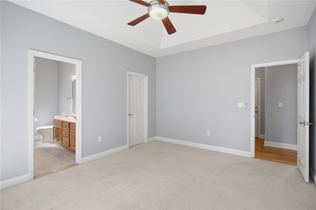 201 Providence Court Seneca, SC 29678 - Photo 18 of 33 This spacious bedroom offers comfortable carpeting and a tray ceiling with a fan.