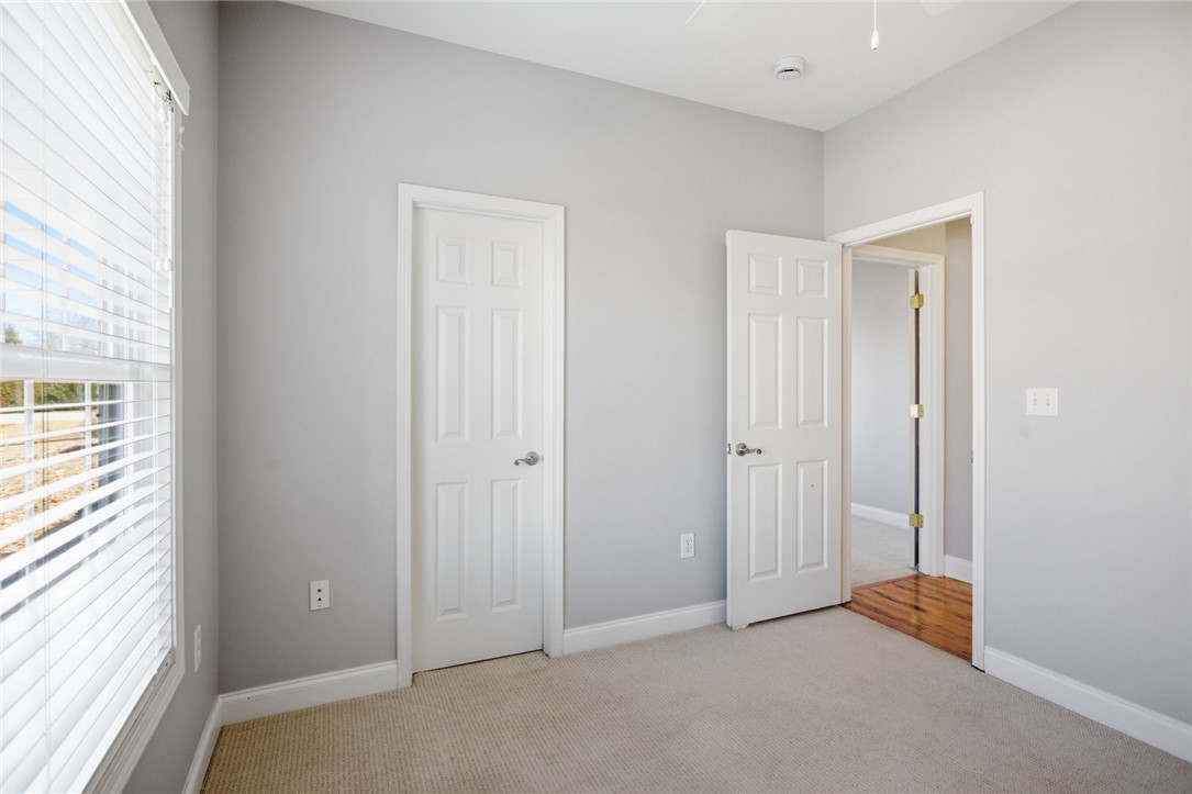 201 Providence Court Seneca, SC 29678 - Photo 22 of 33 This cozy bedroom features light gray walls, plush carpeting, and a bright window with blinds.