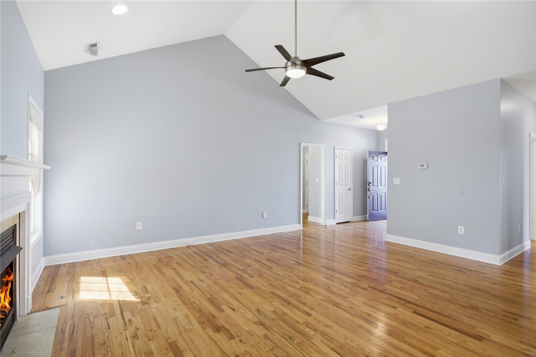 201 Providence Court Seneca, SC 29678 - Photo 9 of 33 This expansive living area features a captivating fireplace and gleaming hardwood floors.