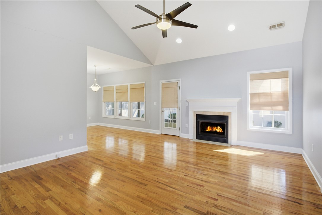 201 Providence Court Seneca, SC 29678 - Photo 10 of 33 This airy room features rich hardwood flooring and a cozy fireplace, creating an inviting atmosphere.