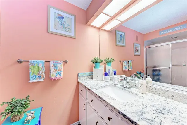 a bathroom with a granite countertop sink a mirror and a bathtub