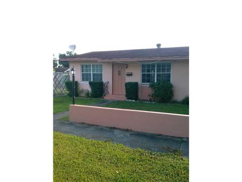 a view of house with a yard and potted plants