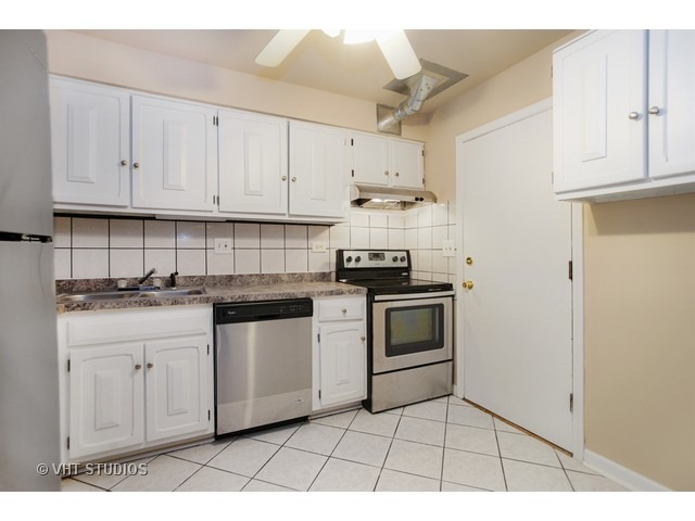 2315 South Goebbert Road, Unit D106 Arlington Heights, IL 60005 - Photo 3 of 11 a kitchen with white cabinets and appliances