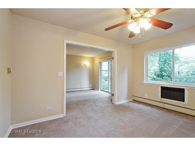 2315 South Goebbert Road, Unit D106 Arlington Heights, IL 60005 - Photo 4 of 11 a view of a livingroom with an empty space and a window