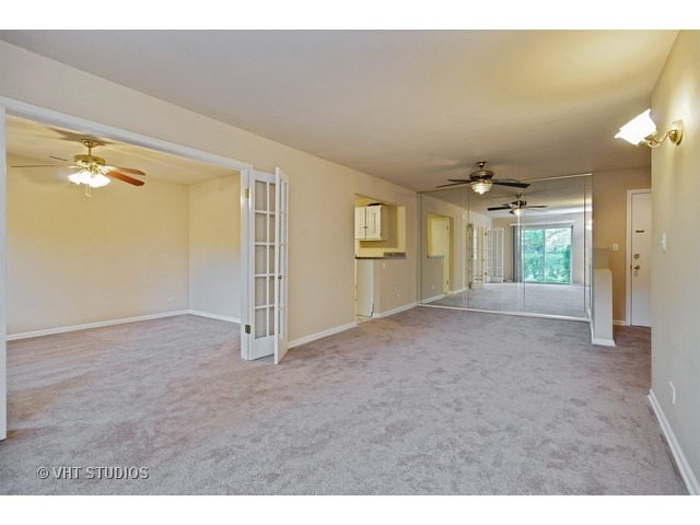 2315 South Goebbert Road, Unit D106 Arlington Heights, IL 60005 - Photo 5 of 11 a view of a big room with windows and chandelier fan