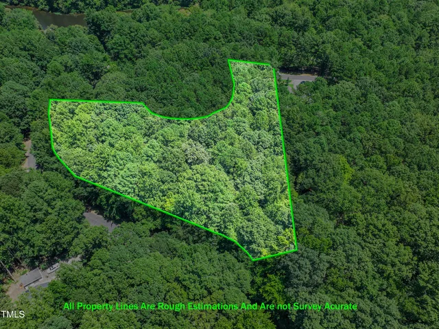 a view of a lush green forest with trees and houses