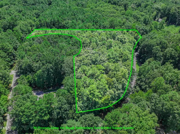 an aerial view of residential house with outdoor space and trees all around