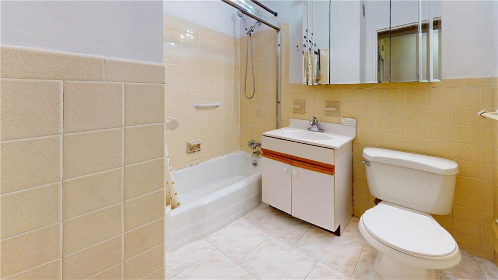 2932 West 5th Street, Unit 15H Brooklyn, NY 11224 - Photo 8 of 15 a bathroom with a toilet sink vanity and mirror