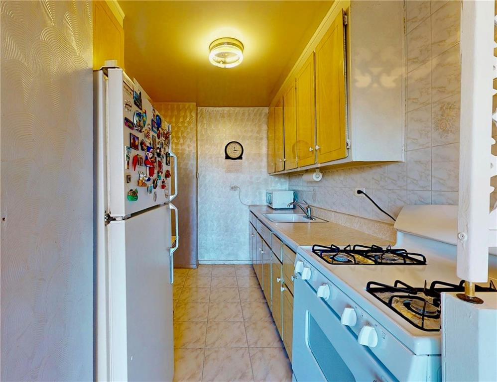 2932 West 5th Street, Unit 15H Brooklyn, NY 11224 - Photo 9 of 15 a kitchen with a stove and a refrigerator