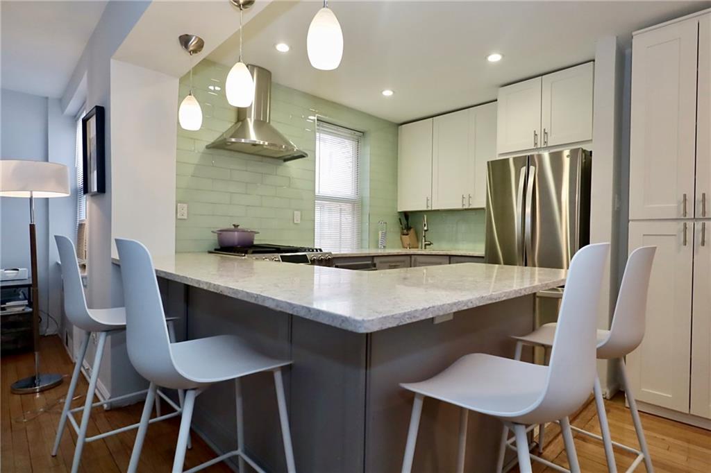 302 96th Street, Unit 3P Brooklyn, NY 11209 - Photo 6 of 19 a kitchen with stainless steel appliances granite countertop a sink a stove a refrigerator with a dining table and chairs