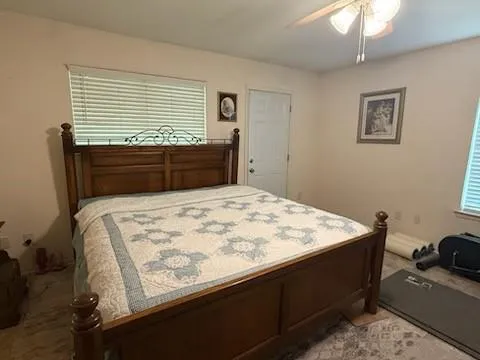 a bedroom with a bed a couch and a chandelier