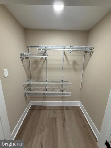 an empty room with wooden floor and bathroom