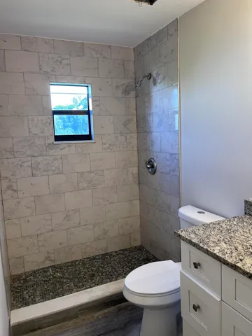 a bathroom with a granite countertop bathtub toilet and sink