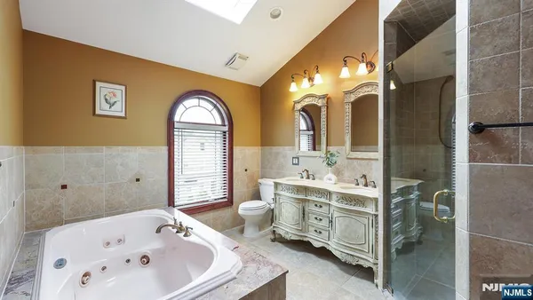 a bathroom with a tub sink and mirror