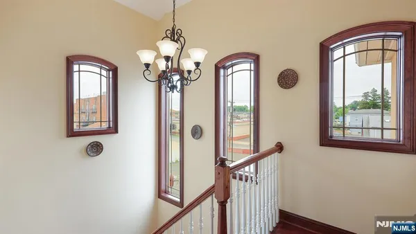 a view of a hallway with windows chandelier