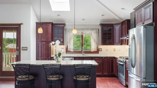 a kitchen with stainless steel appliances granite countertop a refrigerator and a stove