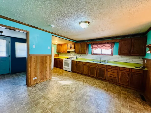 a kitchen with stainless steel appliances granite countertop a refrigerator and a stove top oven
