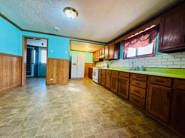 a kitchen with stainless steel appliances granite countertop a refrigerator and a stove top oven