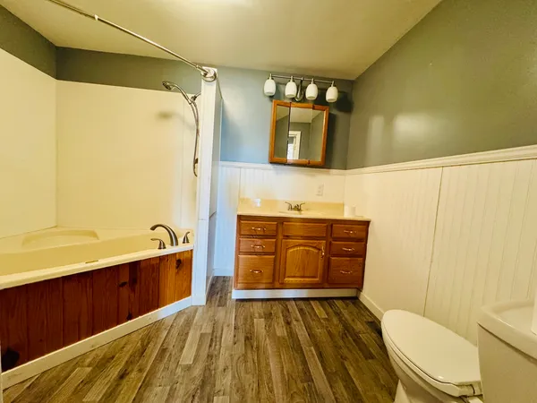 a bathroom with a sink a toilet and shower