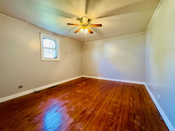 a view of a room with wooden floor and fan