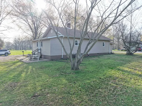 a view of a house with backyard and a tree