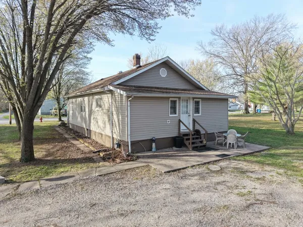 a view of house with backyard and trees