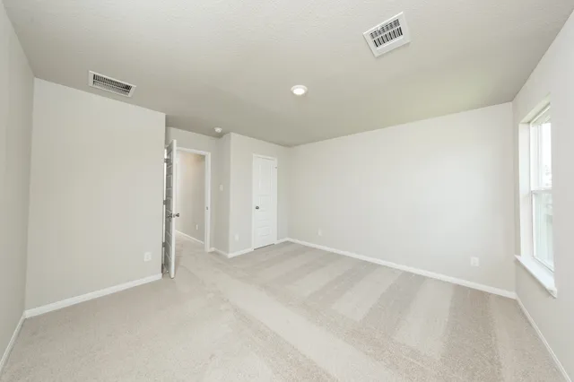 an empty room with windows and closet