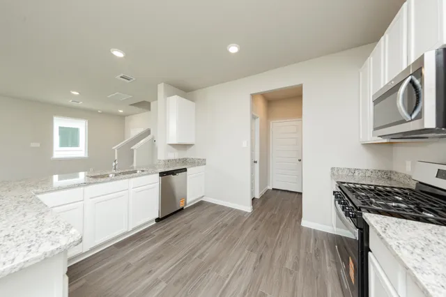 a kitchen with a stove a sink and a microwave