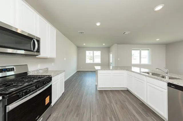 a kitchen with a sink stove top oven and cabinets