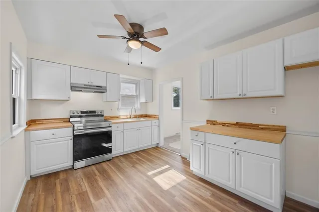 a kitchen with granite countertop white cabinets and white appliances
