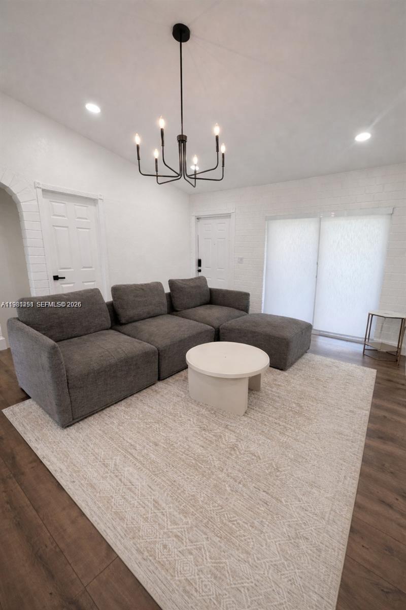 12504 Southwest 112th Terrace Miami, FL 33186 - Photo 2 of 12 a living room with furniture a window and a chandelier