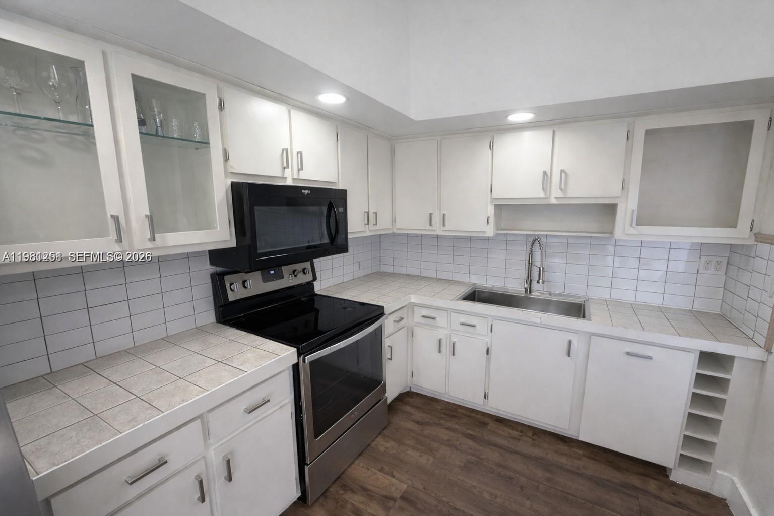 12504 Southwest 112th Terrace Miami, FL 33186 - Photo 3 of 12 a kitchen with a sink stove and cabinets