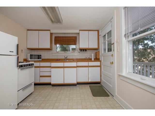 808 Tuxedo Lane Cary, IL 60013 - Photo 17 of 28 a kitchen with kitchen island granite countertop a sink window and white stainless steel appliances