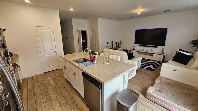 a kitchen with a sink a stove and white cabinets