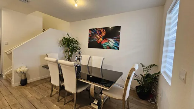 a room with furniture a flat screen tv and kitchen view