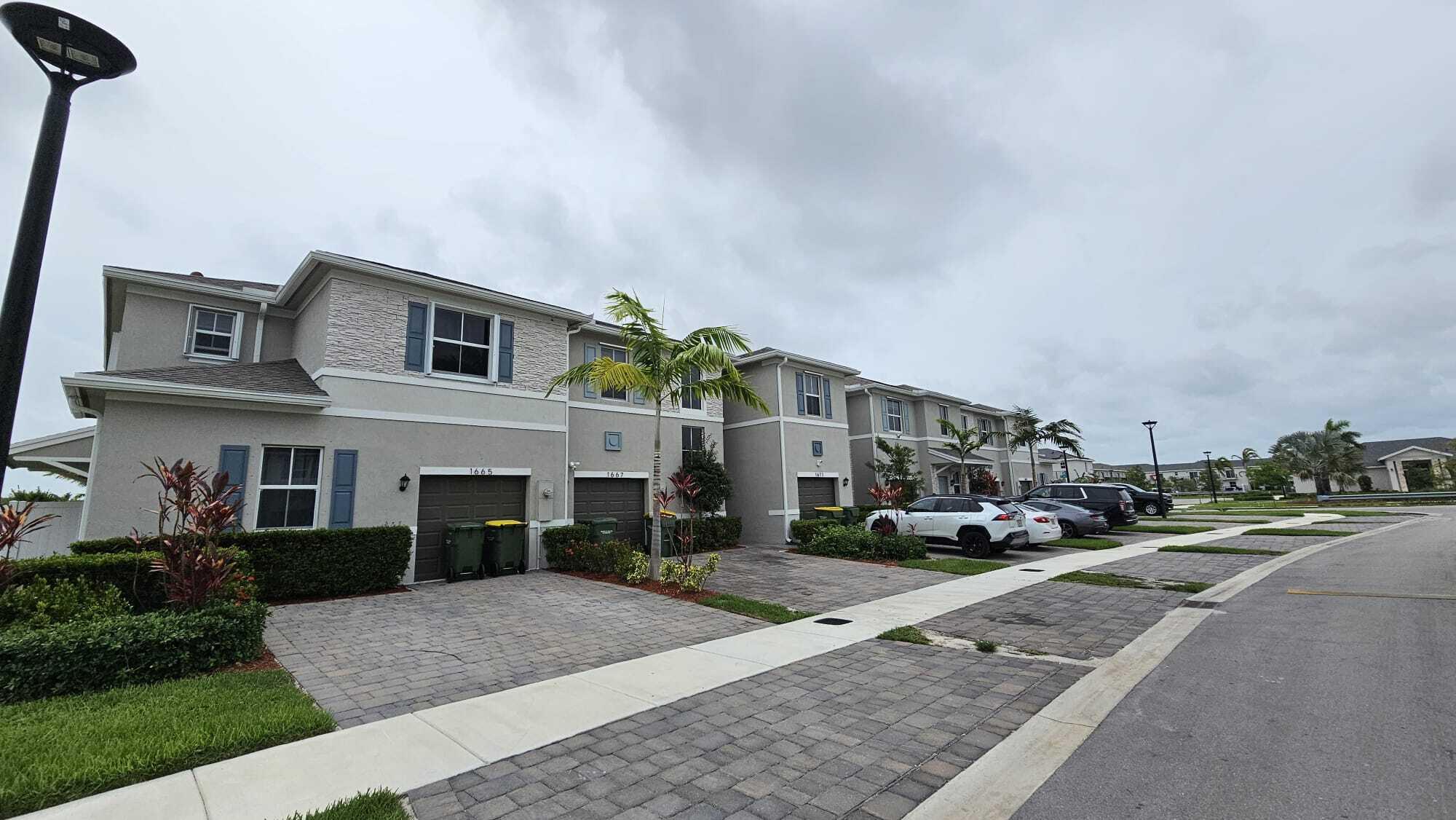 1677 Southeast 8th Street Homestead, FL 33034 - Photo 3 of 52 a front view of a house with a yard and garage