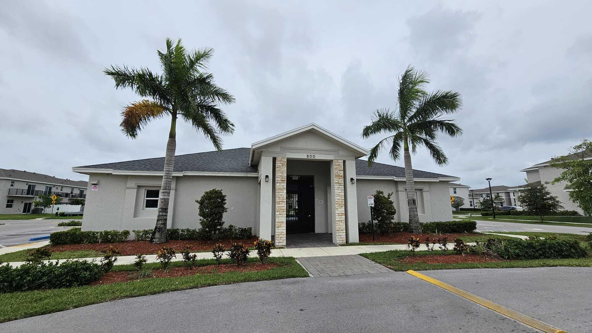 1677 Southeast 8th Street Homestead, FL 33034 - Photo 46 of 52 a front view of a house with a garden and palm trees