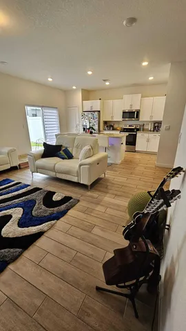 a living room with furniture a large window and a table