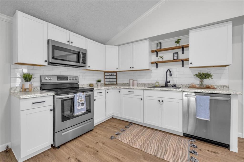 9597 Highway 334 Nicholson, GA 30565 - Photo 17 of 41 a kitchen with granite countertop white cabinets sink and stainless steel appliances