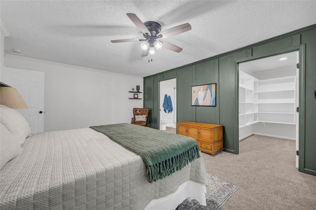 9597 Highway 334 Nicholson, GA 30565 - Photo 22 of 41 a spacious bedroom with a bed and a chandelier