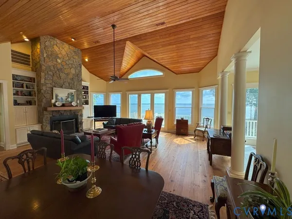 a dining room with furniture a fireplace and wooden floor