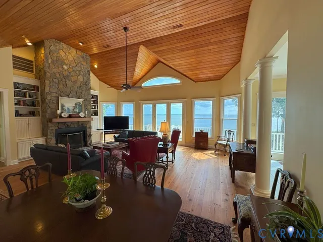 a dining room with furniture a fireplace and wooden floor